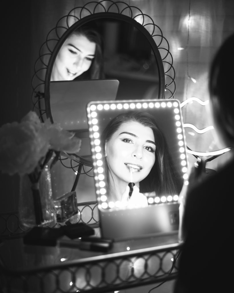 RIKI LOVES RIKI Skinny Vanity Lighted Mirror on vanity table with Farah Gasimzade, Founder of Sun Kissed Blush, in reflection